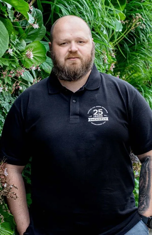 Porträt Daniel Terek, BSc vor einer Grünwand